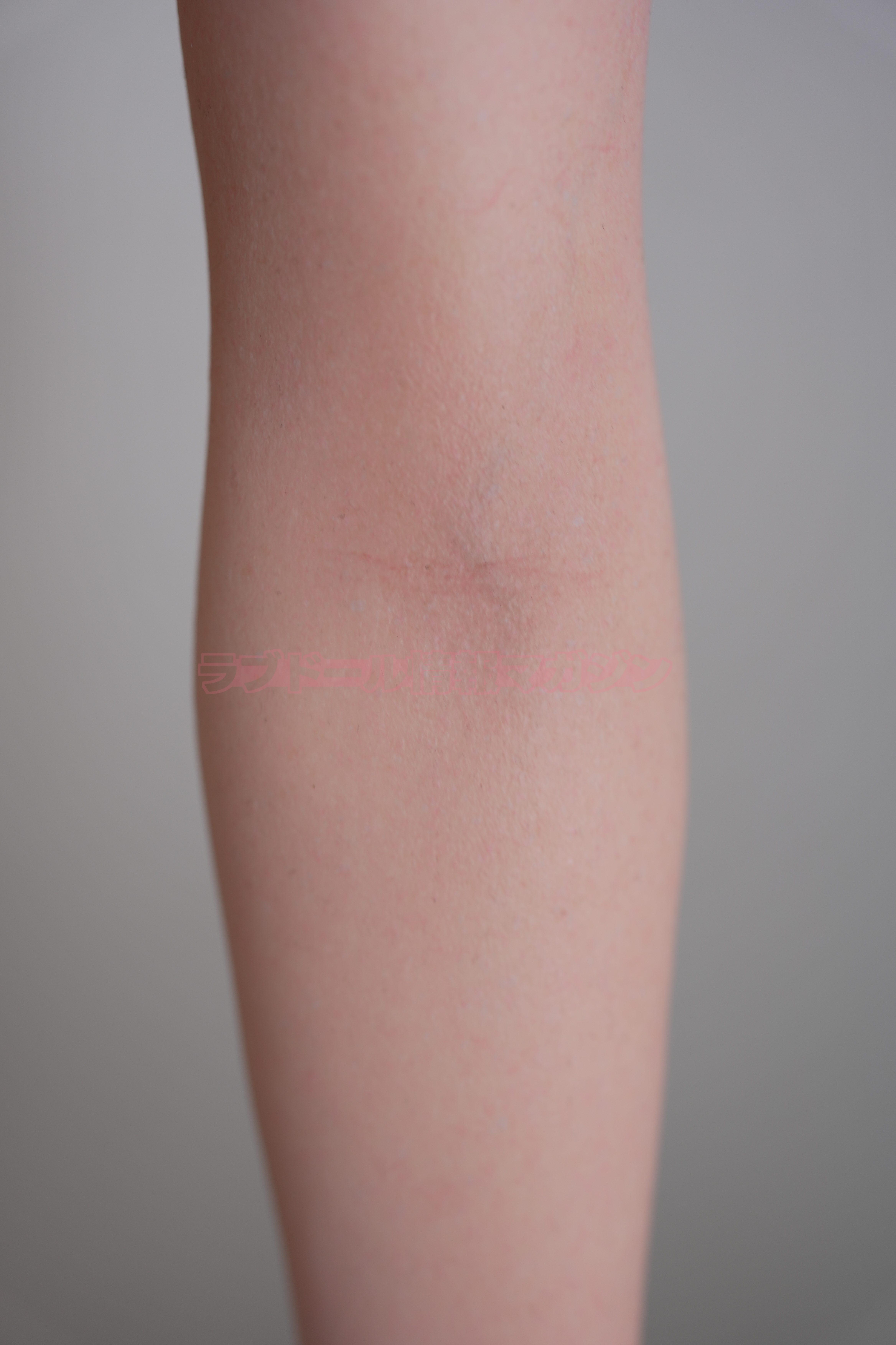 A close-up view of a realistic silicone doll's inner thigh, showing skin texture and subtle details.