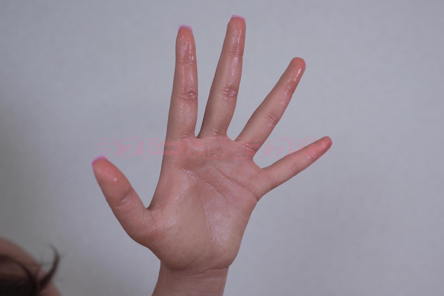 Close-up of a hand showing realistic skin texture and a gesture. The hand has glossy finish and well-defined fingers.