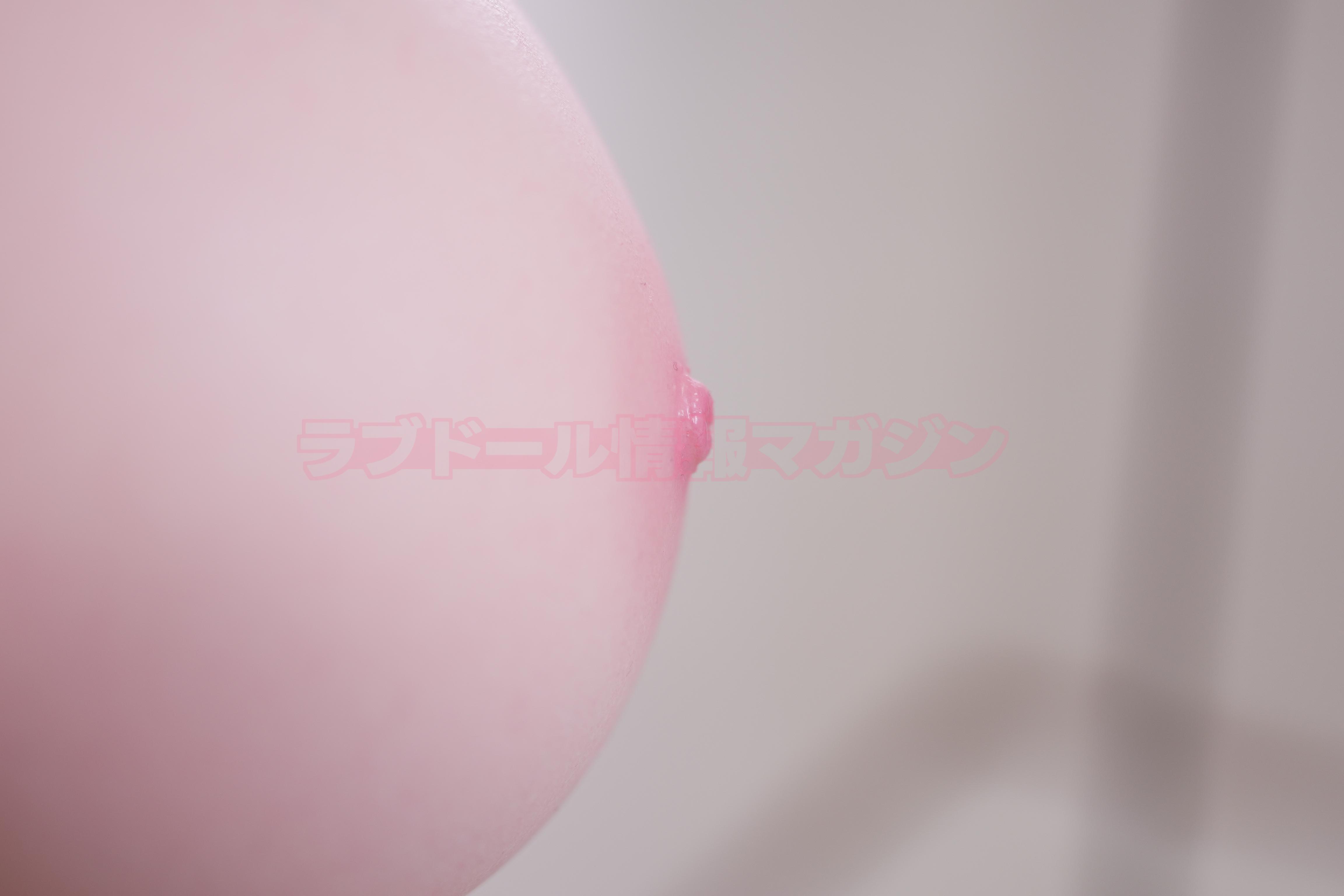 Close-up image of a soft skin texture of a doll, highlighting a nipple detail with slight shine.