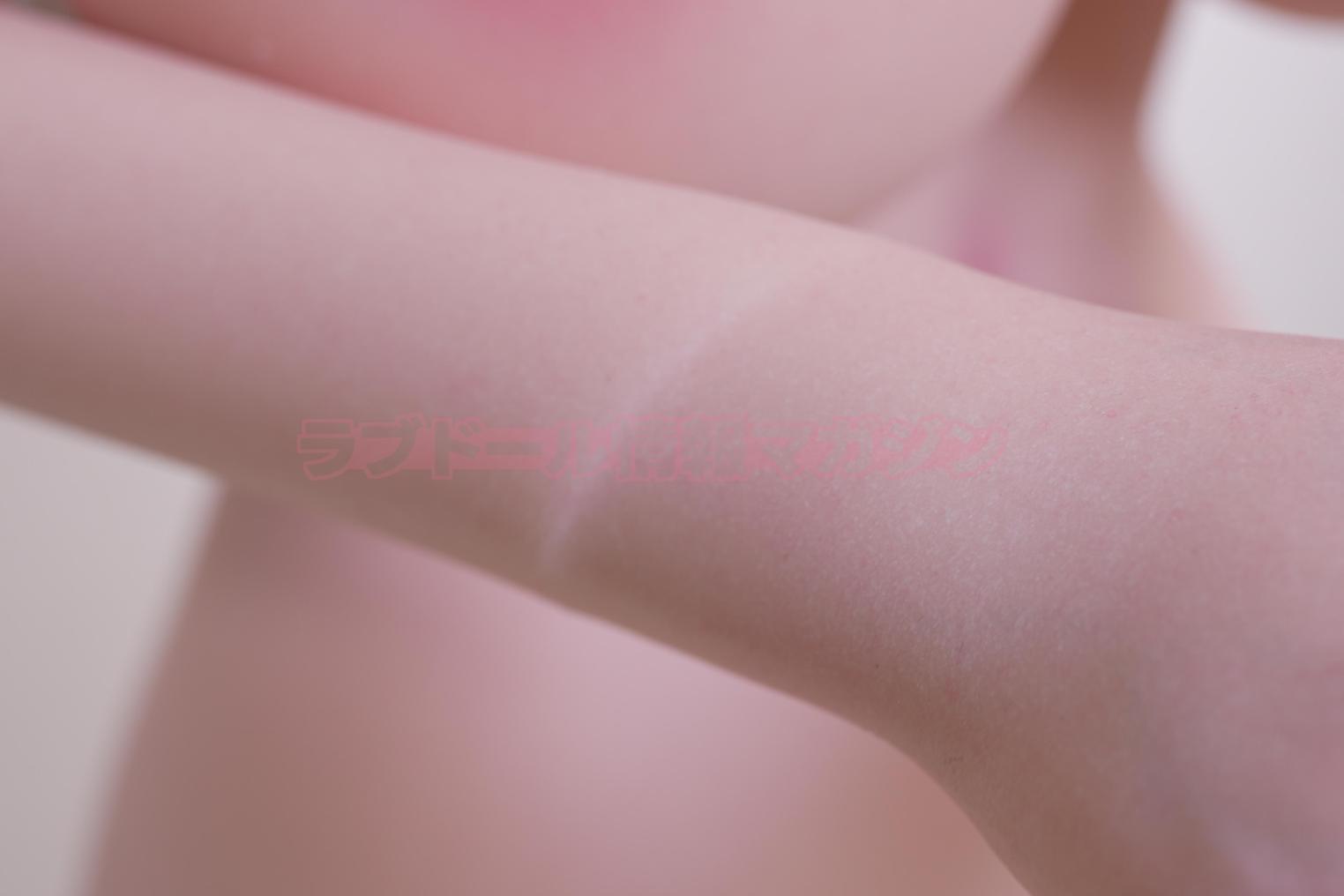 Close-up of a realistic skin texture on a love doll's arm, highlighting soft details.