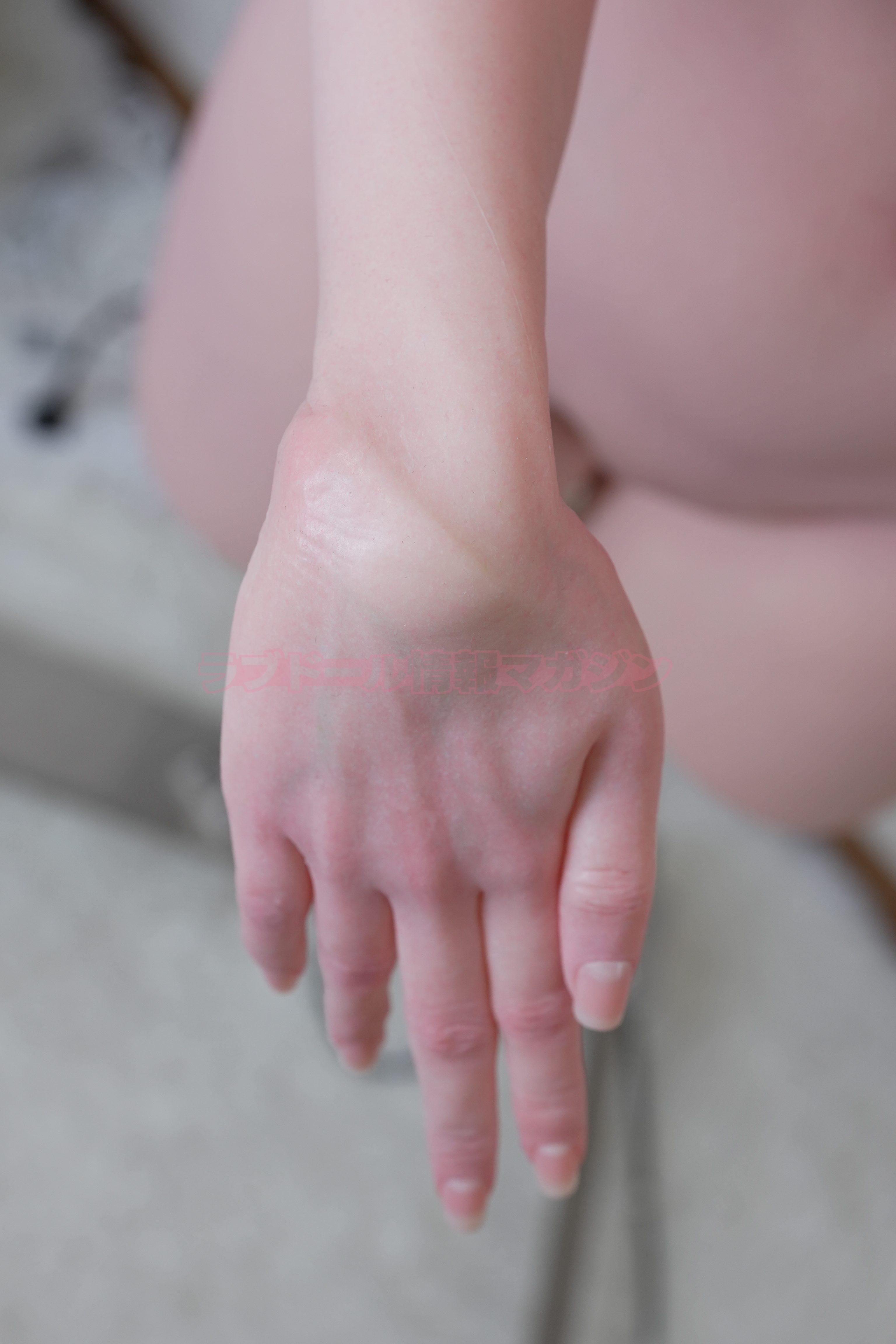 Close-up view of a realistic hand with detailed skin texture, showcasing lifelike features and slightly bent fingers.