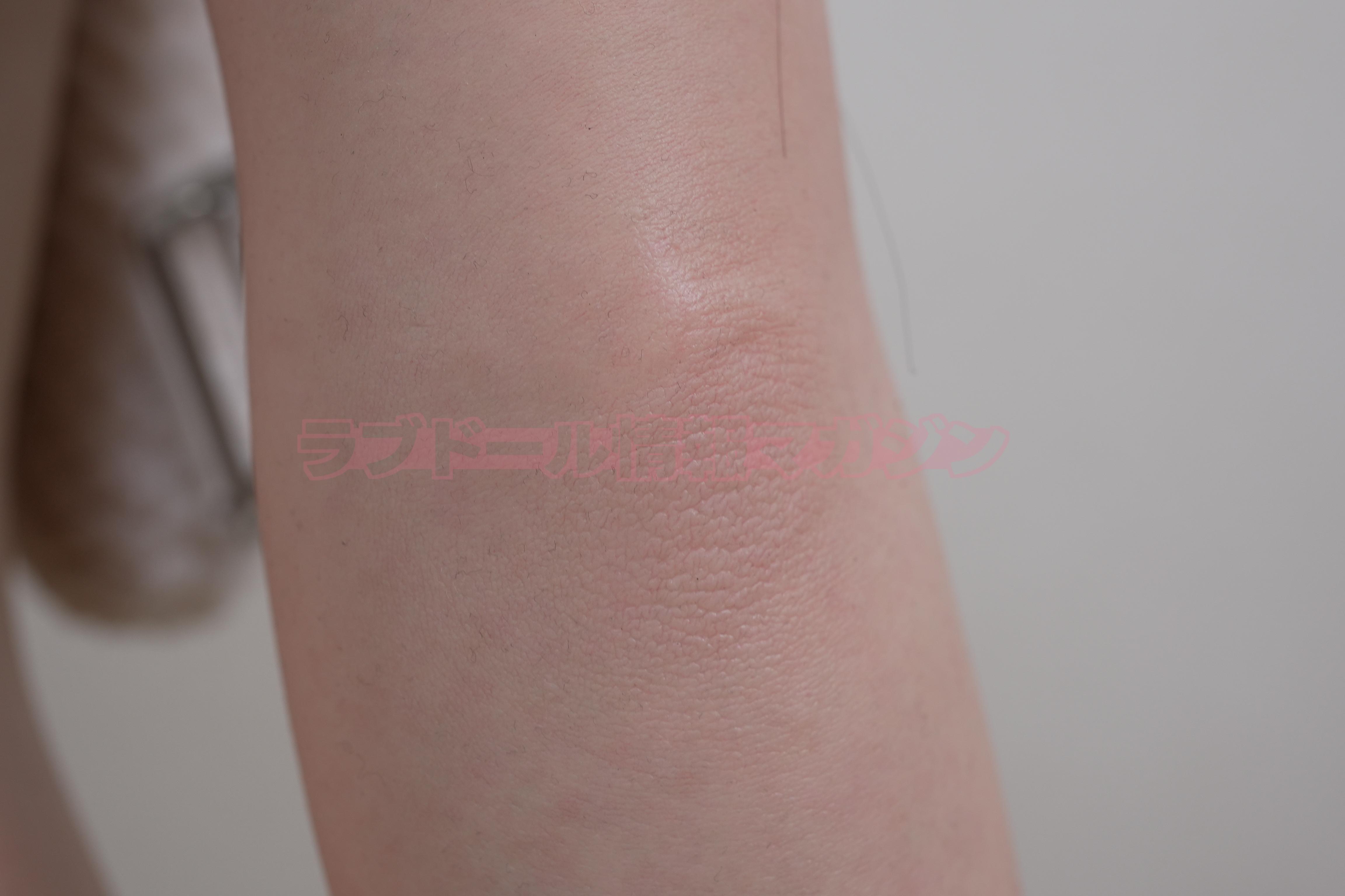 Close-up view of realistic skin texture on a silicone doll's thigh, showcasing detail and softness.