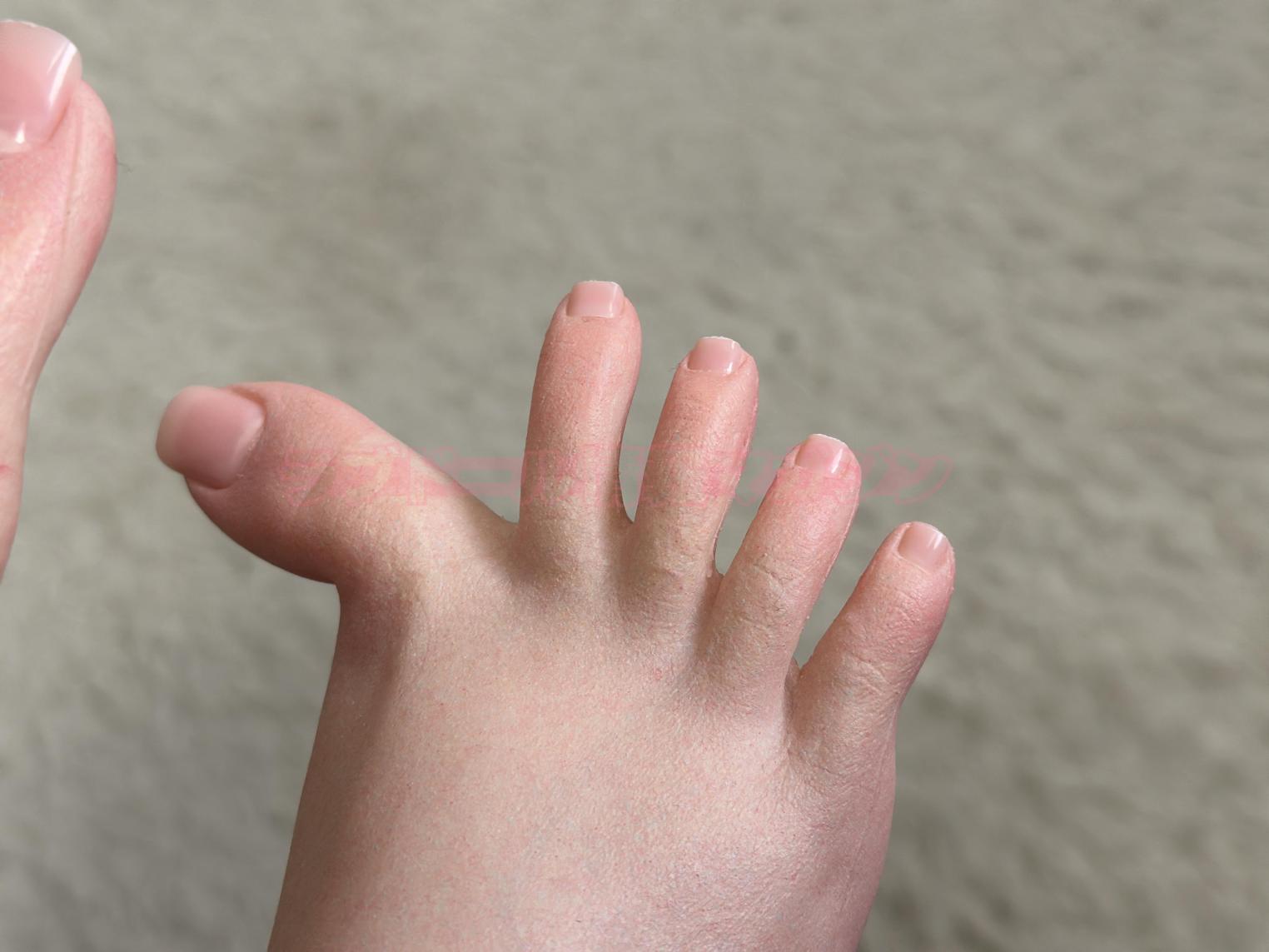 Close-up of a realistic silicone doll hand and foot showcasing detailed skin texture and nail design.
